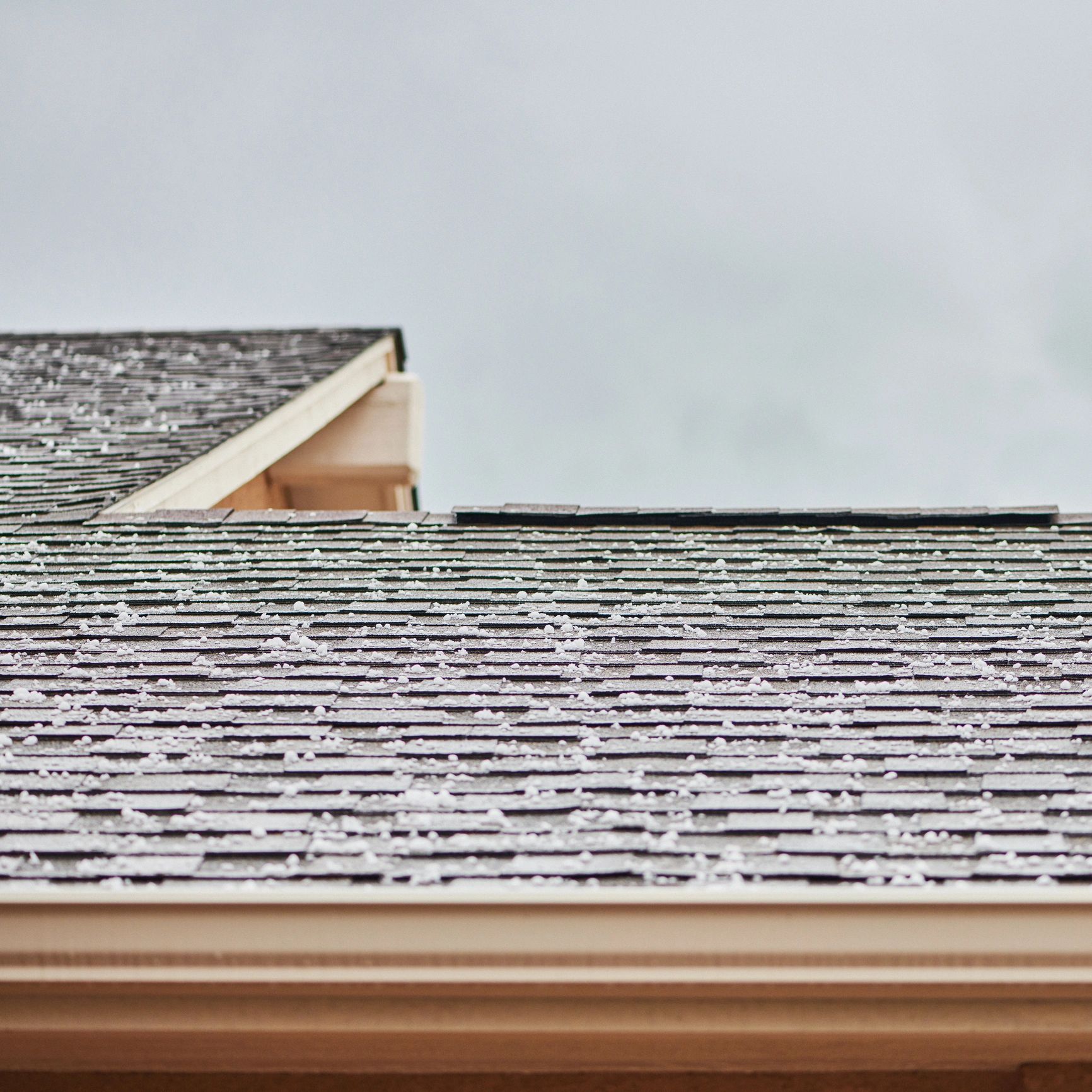 Roofer installing shingles on residential home